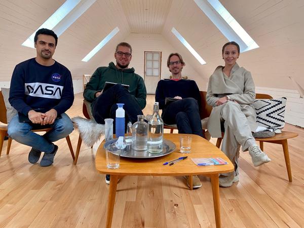 Photograph of (from left to right) Andre Staltz, Henry, Anders, and Zenna sitting on chairs facing the camera and smiling